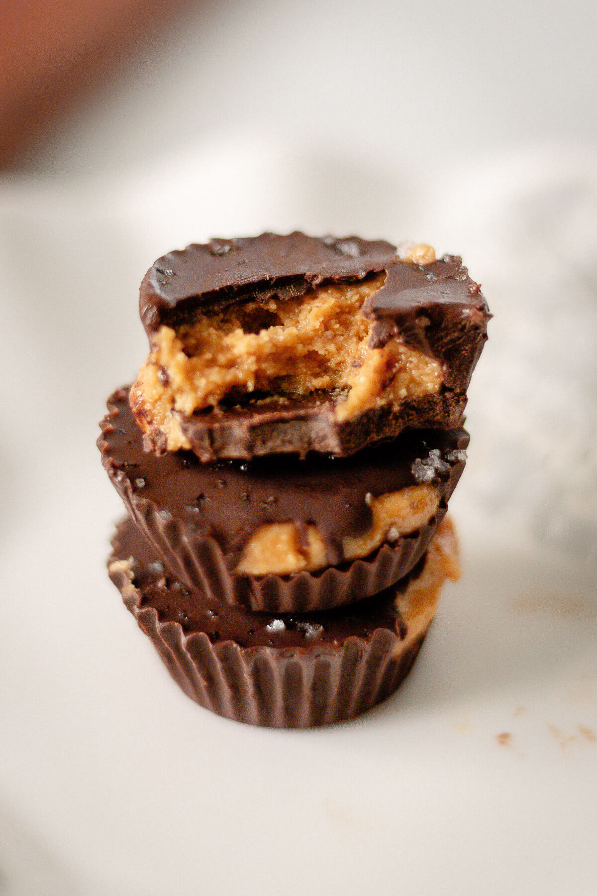 close up view of stack of homemade chocolate peanut butter cups with sea salt topping
