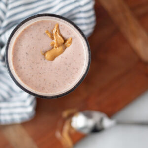 top down view of a strawberry peanut butter smoothie in a glass