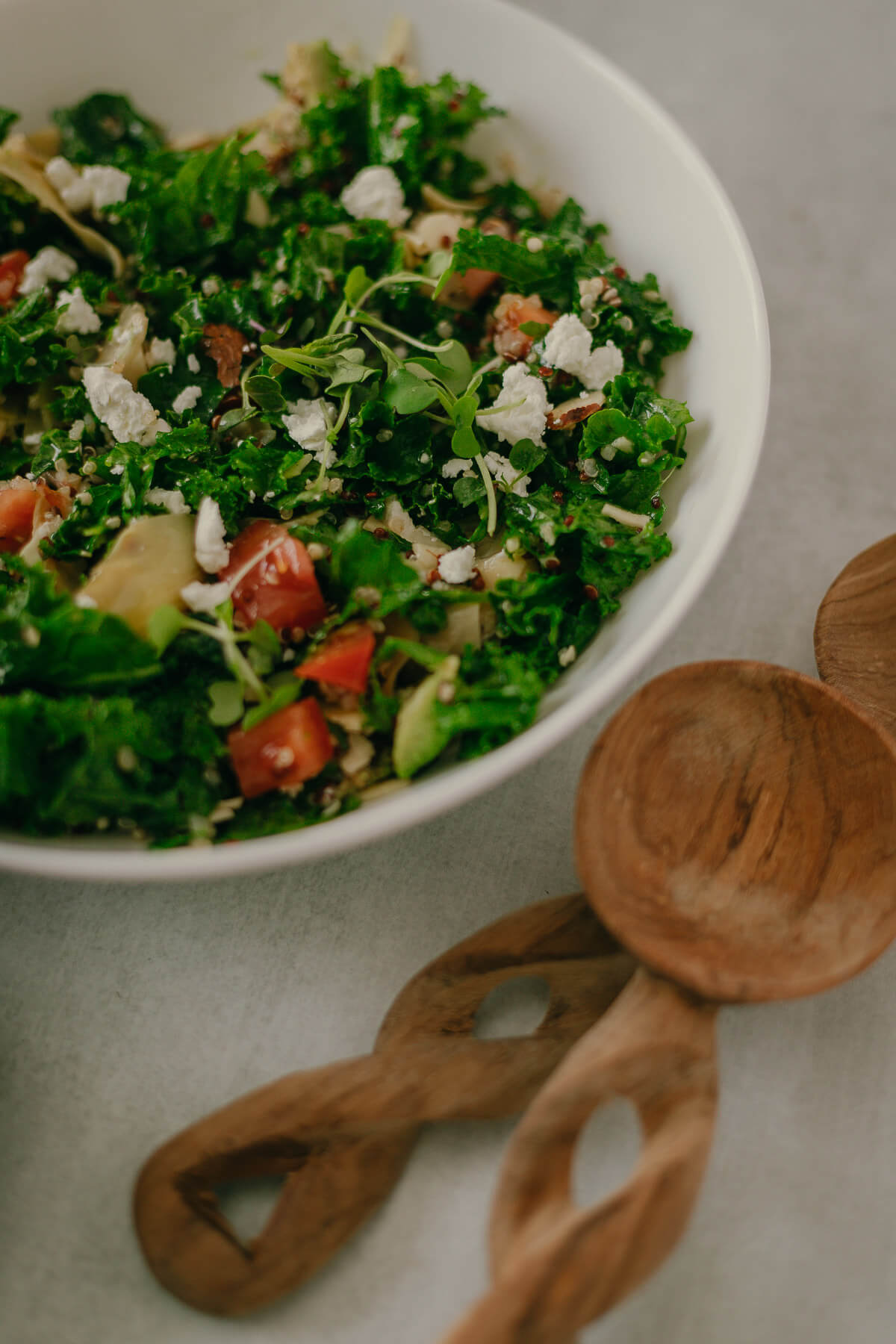 kale quinoa salad with goat cheese and artichokes in a lemon dressing