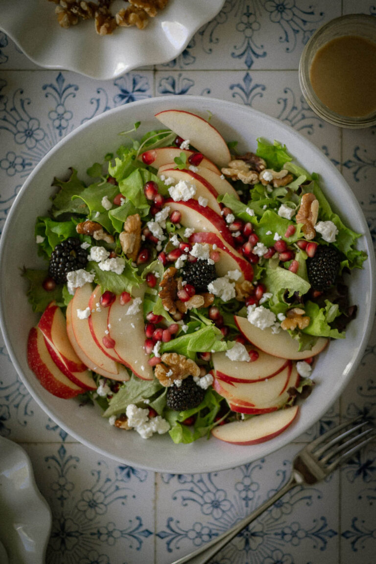 Autumn Harvest Salad with apples goat cheese blackberries walnuts and pomegranate arils.