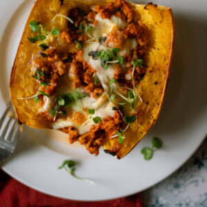 Roasted Spaghetti Squash half with turkey meat sauce and mozzarella cheese for a delicious turkey spaghetti squash bake.
